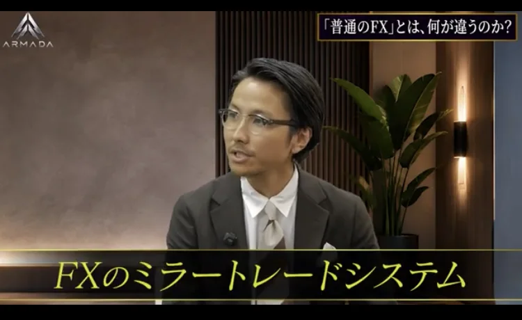 「FXのミラートレードシステム」と字幕が出た説明動画で、インタビューに答える安森一貴の映像