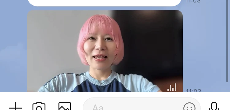 LINEのトーク画面に届いた動画。ピンク色の髪の女性が正面を向いて話している場面が表示されている